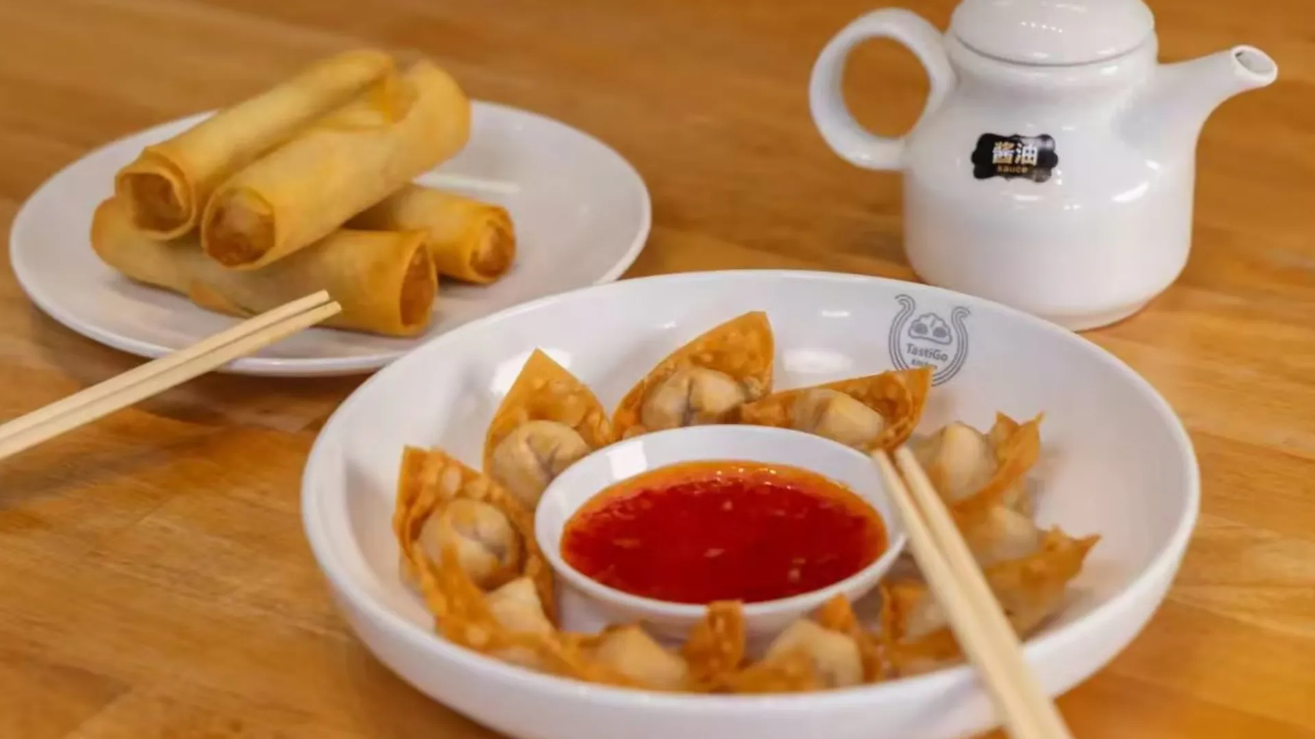 Crispy spring rolls and fried wontons with sauce at TastiGo Kitchen, an Asian Fusion Restaurant in Miami
